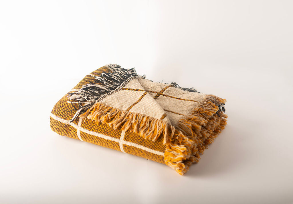 Greer Acorn grid throw folded to show its lighter reversible side and contrasting fringe