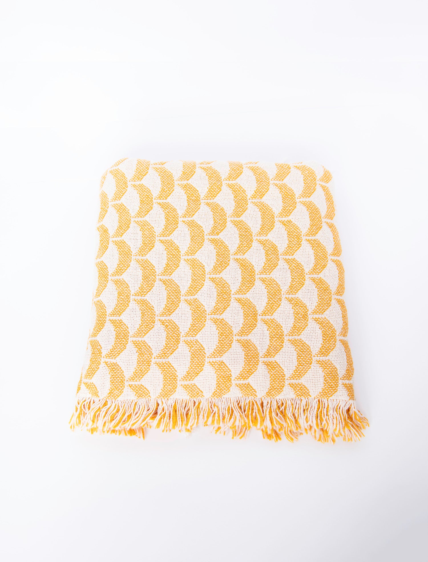 Front view of folded yellow and cream scallop woven cotton throw on a white background