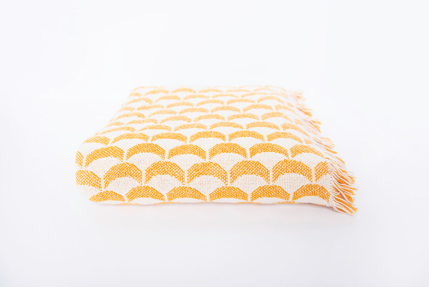 Side view of folded Sadie golden yellow scallop woven throw with fringe